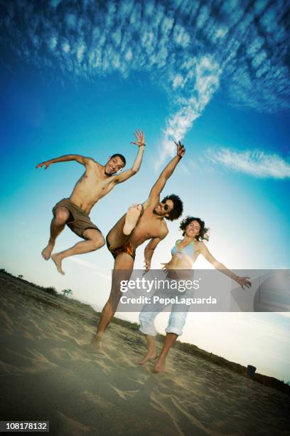 três jovens peopl cama e tendo diversão na praia - dar uma ajuda imagens e fotografias de stock