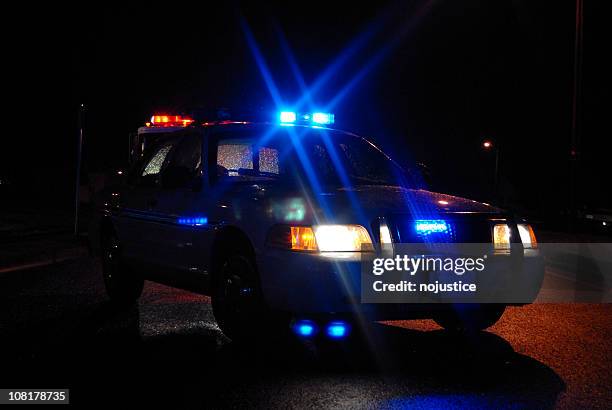 police car at night with lights on - police car stock pictures, royalty-free photos & images