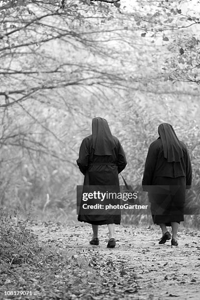 two nuns walking through park, black and white - nun stock pictures, royalty-free photos & images