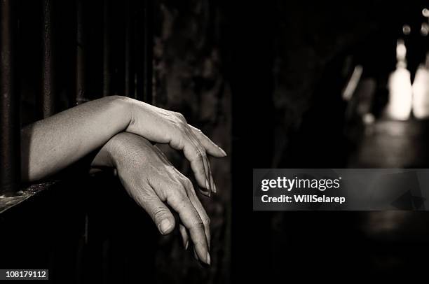 hands in cage - women in prison stock pictures, royalty-free photos & images