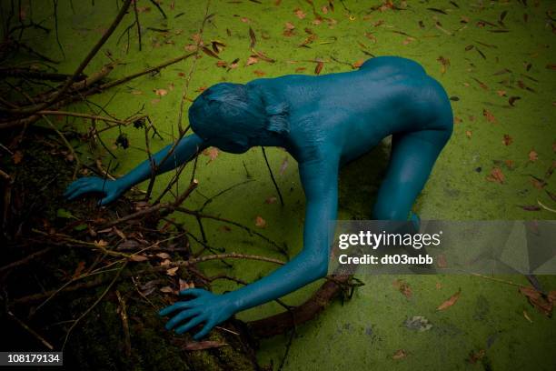 blue body painted woman crawling out of swamp - swamp monster stock pictures, royalty-free photos & images