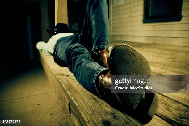 nappin on the front porch - cowboy sleeping stock pictures, royalty-free photos & images