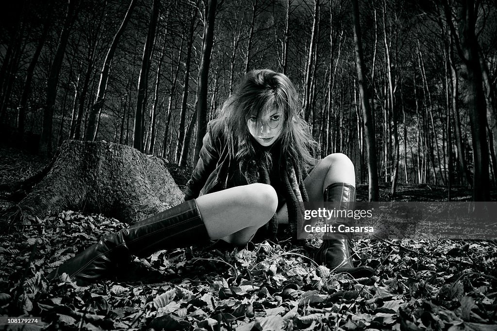Young Woman Sitting Leaves on Forest Floor, Toned