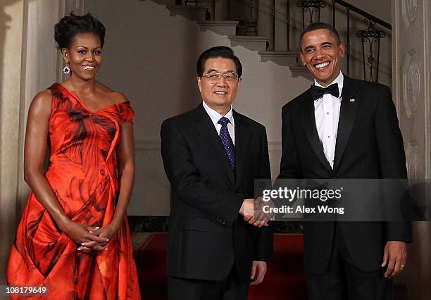 President Barack Obama shakes hands with Chinese President Hu Jintao as first lady Michelle Obama looks on as they pose for the official photo at the...