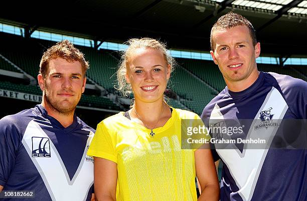 Caroline Wozniacki of Denmark poses with Australian cricketers Peter Siddle and Aaron Finch after receiving a cricket lesson during day four of the...