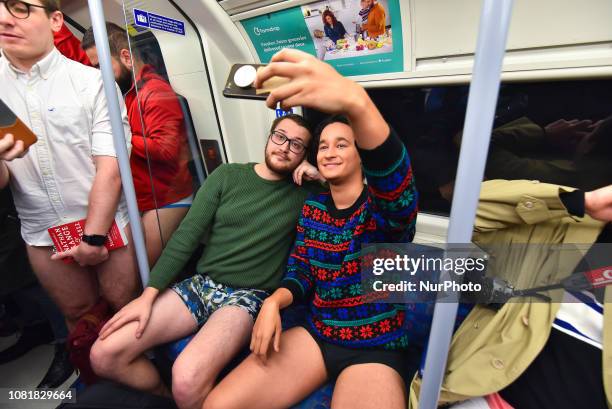 People take part in the annual 'No Trousers On The Tube Day' on the London Underground Jubilee Line, posing for photographs at Canary Wharf, in...