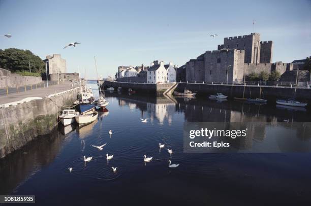 General view of medieval castle Rushen the neighbouring pub the Castle Arms by the Silverburn river, Castletown, Isle of Man, July 1982.