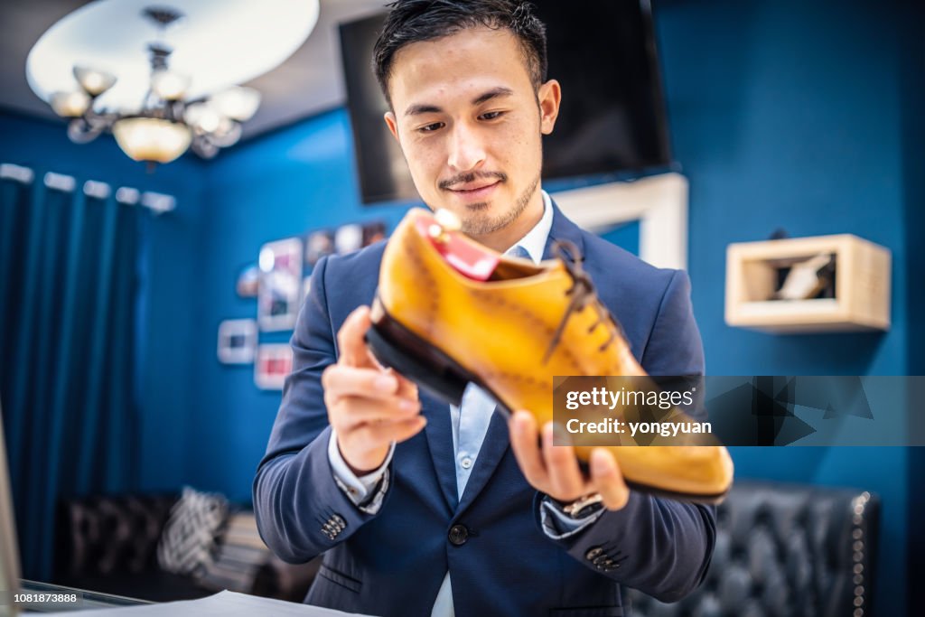 Shoemaker checking a leather shoe