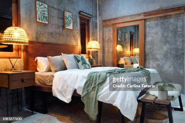 luxury concrete bedroom at night - bedclothes stock-fotos und bilder