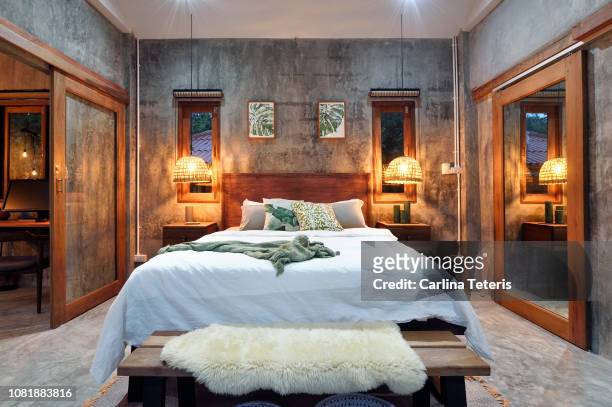 stylish tropical bedroom at night - hotel bedroom stock pictures, royalty-free photos & images