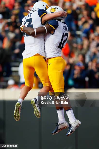 Wide receiver Gary Jennings Jr. #12 of the West Virginia Mountaineers celebrates a 13-yard touchdown run with wide receiver David Sills V against the...