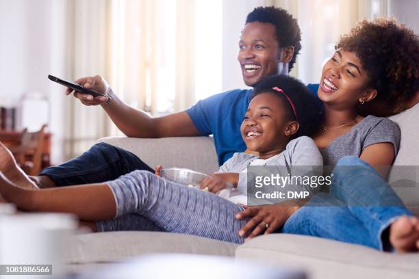 disfruta de toneladas de shows familiar juntos - familia viendo television fotografías e imágenes de stock