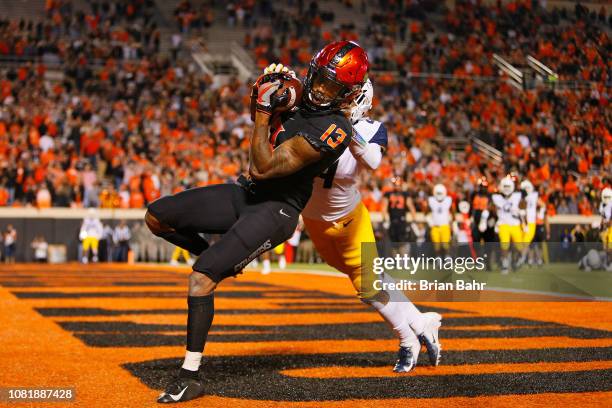 Wide receiver Tyron Johnson of the Oklahoma State Cowboys pulls in a touchdown catch against cornerback Josh Norwood of the West Virginia...