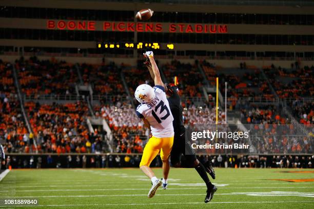 Wide receiver David Sills V of the West Virginia Mountaineers can't reach a pass over his head under coverage from cornerback A.J. Green of the...