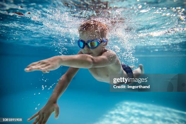 プールでクロールを泳ぐ小さな男の子 - swimming underwater ストックフォトと画像