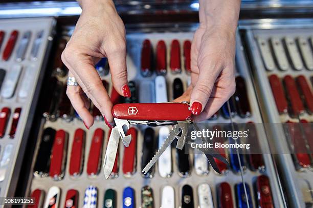 An employee displays a Swiss army penknife for sale at the Victorinox AG factory store in Ibach, Switzerland, on Thursday, Jan. 20, 2011. Victorinox,...