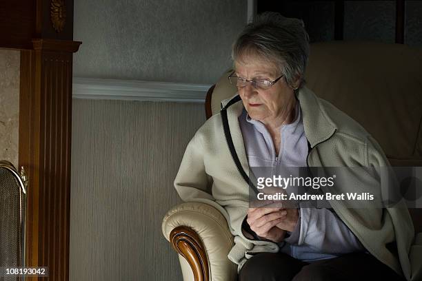 senior woman feeling the cold in her home - froid photos et images de collection