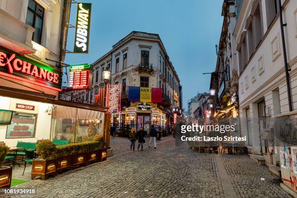People walk on Strada Selari in the Centru Vechi on December 7, 2018 in Bucharest, Romania. Bucharest's Old Town is defined by the area bordered by...