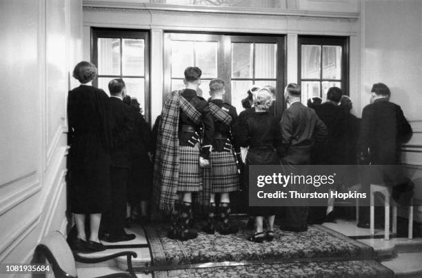 Latecomers and people without tickets crowd round the doors to watch a charity show of the new collection by French fashion designer Christian Dior,...