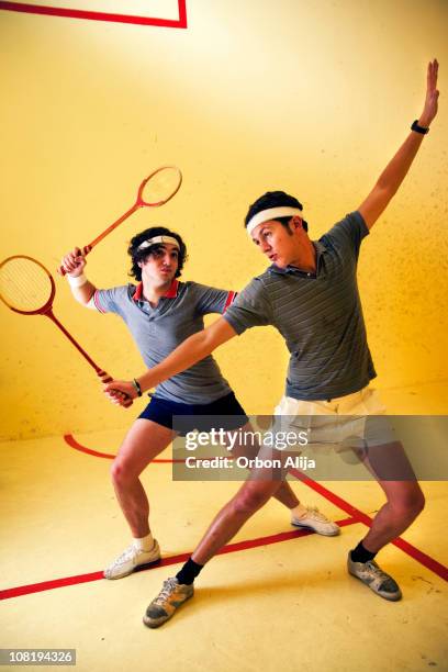 two men posing and playing squash on court - squash sport stockfoto's en -beelden