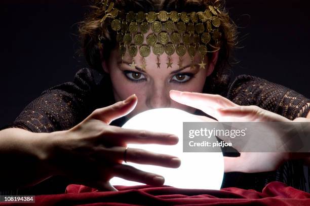 fortune teller with glowing crystal ball - crystal ball stock pictures, royalty-free photos & images