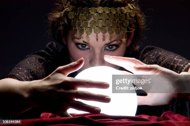 fortune teller with glowing crystal ball - wizards stock pictures, royalty-free photos & images