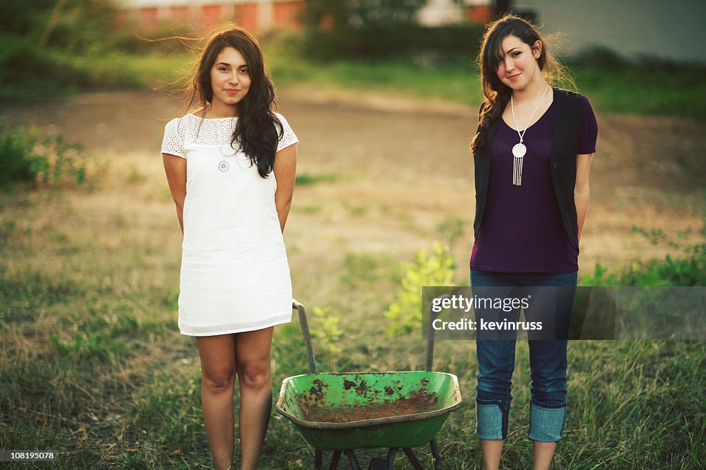 Two Young Women with a Wheel Barrow