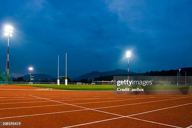 track and field stadium at night - athletics field stock pictures, royalty-free photos & images