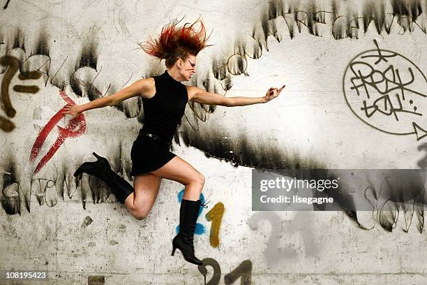 punk woman jumping in urban area - punk rocker stockfoto's en -beelden