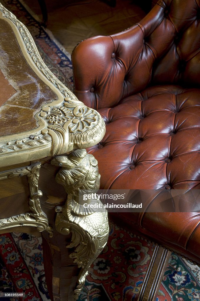 Antique Table and Chesterfield Leather Armchair with Oriental Rug