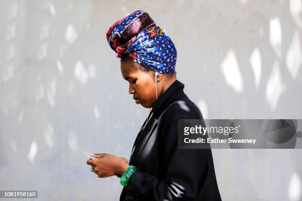 young black woman checks her smart phone - showus phone stock pictures, royalty-free photos & images