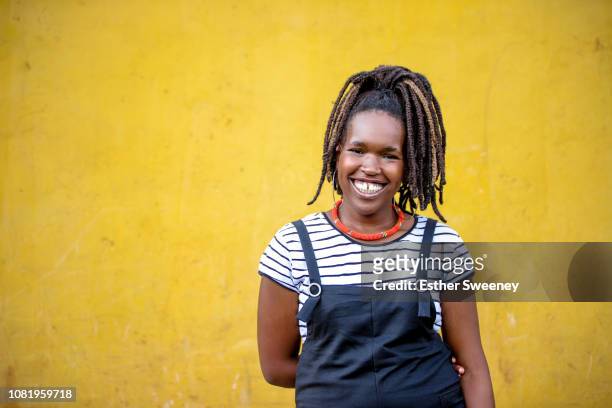 young woman smiling with yellow background - showus ストックフォトと画像