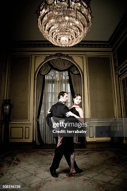 young couple dancing tango in elegant room - tango black stock pictures, royalty-free photos & images