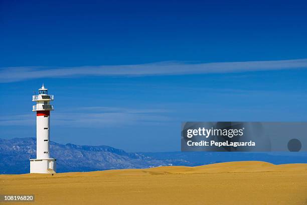 lighthouse on beach with coastline in background - ebro delta stock pictures, royalty-free photos & images