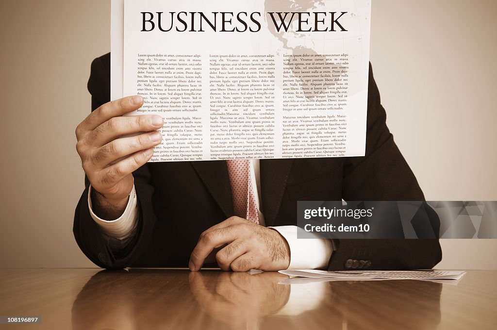 Empresario leyendo el periódico en el mostrador
