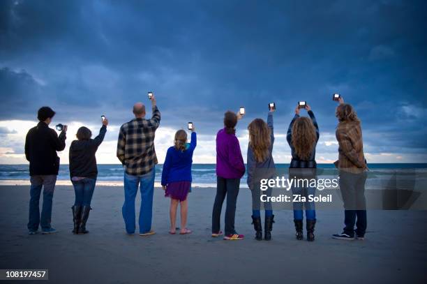 people photographing the sunset with smart phones - fotografieren stock-fotos und bilder