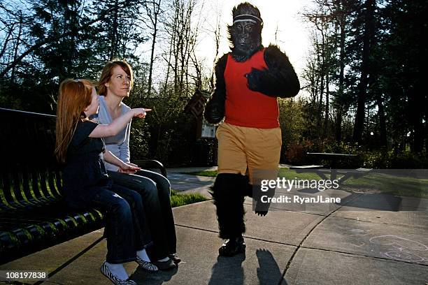 mom & daughter surprised by jogging gorilla - gorilla stock pictures, royalty-free photos & images