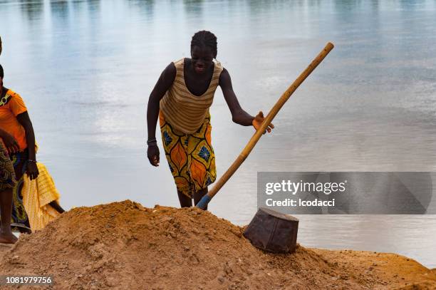 afrikanerin graben schmutzigen sand. niger-gebiet - niger river stock-fotos und bilder