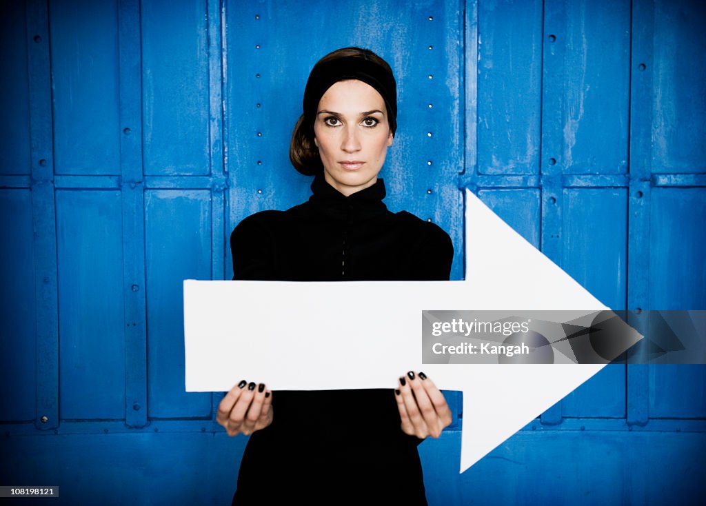 Junge Frau hält großen Pfeil auf der rechten Seite.