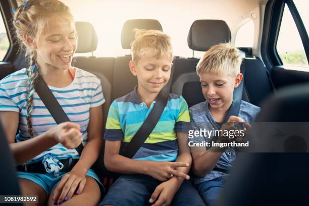 kids playing games in car during road trip - kid playing car imagens e fotografias de stock