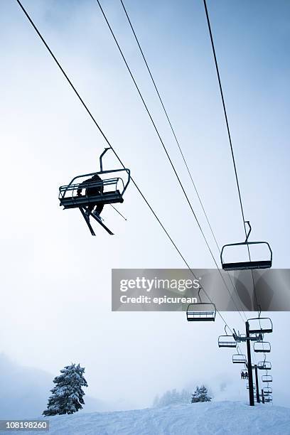 looking up at skier riding ski lift on mountain - mt baker stockfoto's en -beelden