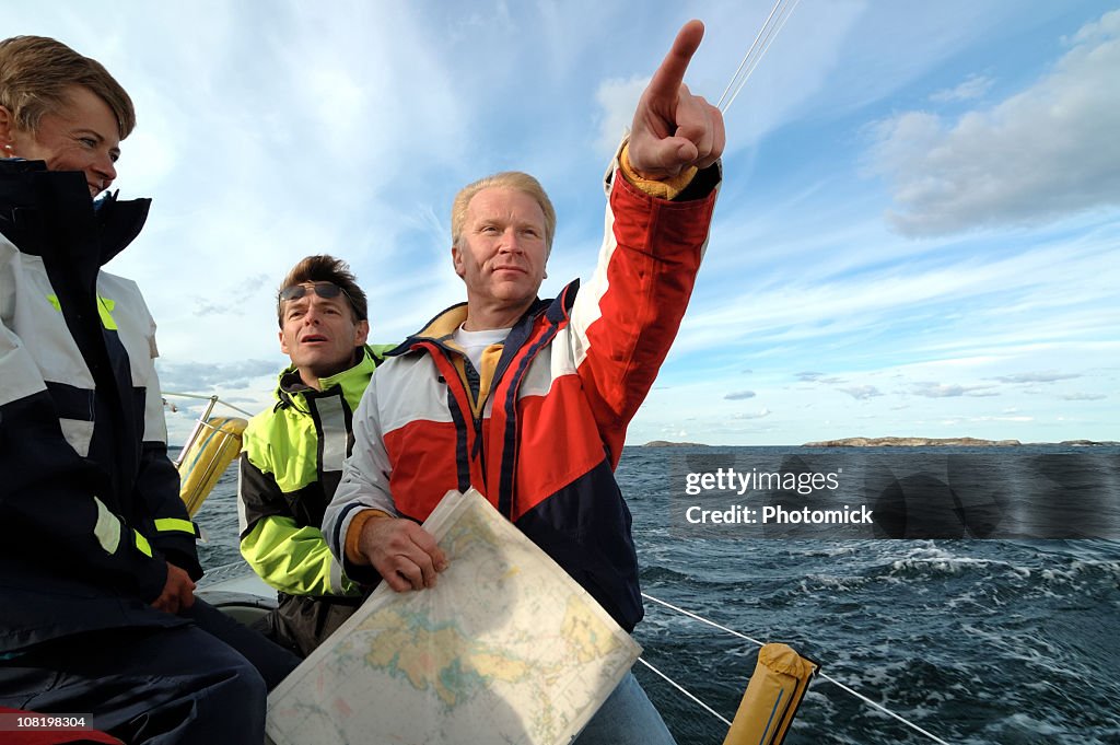 Marinero apuntando hacia delante, gráfico en la mano.