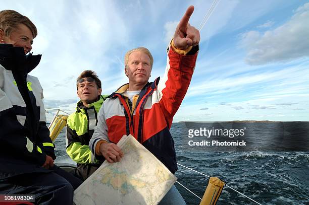 sailor with a chart in his hand pointing forward - roder bildbanksfoton och bilder