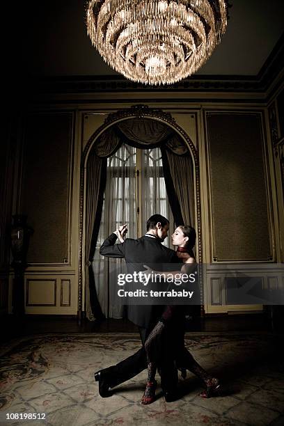 young couple dancing tango in elegant room - tango black stock pictures, royalty-free photos & images