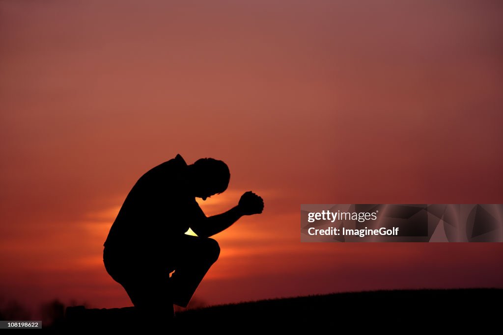 Silhouette of Man Praying at Dusk