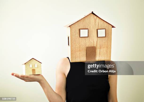 woman wearing house as mask holding smaller, similiar home - miniature dollhouse bildbanksfoton och bilder
