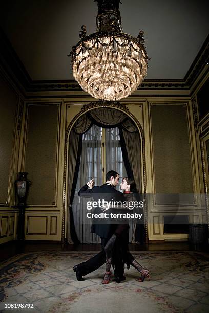 young couple dancing tango in elegant room - balzaal stockfoto's en -beelden