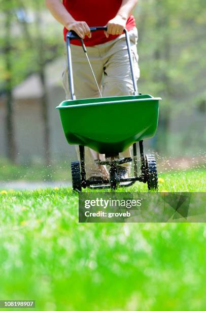 mann fertilizing lawn - dünger stock-fotos und bilder