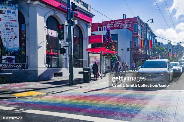 Cyclists and cars are visible approaching the Rainbow Crosswalk, part of the Rainbow Honor Walk commemorating LGBT leaders, on Castro Street in the...