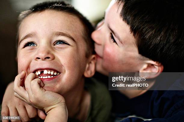 two young brothers smiling and cuddling - tooth fairy stock pictures, royalty-free photos & images